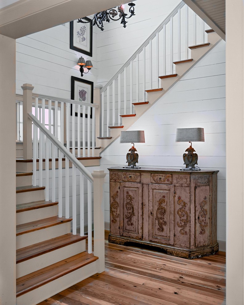 Inspiration pour un escalier rustique en U avec des marches en bois, un garde-corps en bois et éclairage.