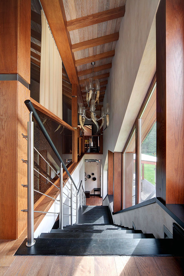 Réalisation d'un grand escalier droit design avec des marches en bois peint, des contremarches en métal et un garde-corps en métal.