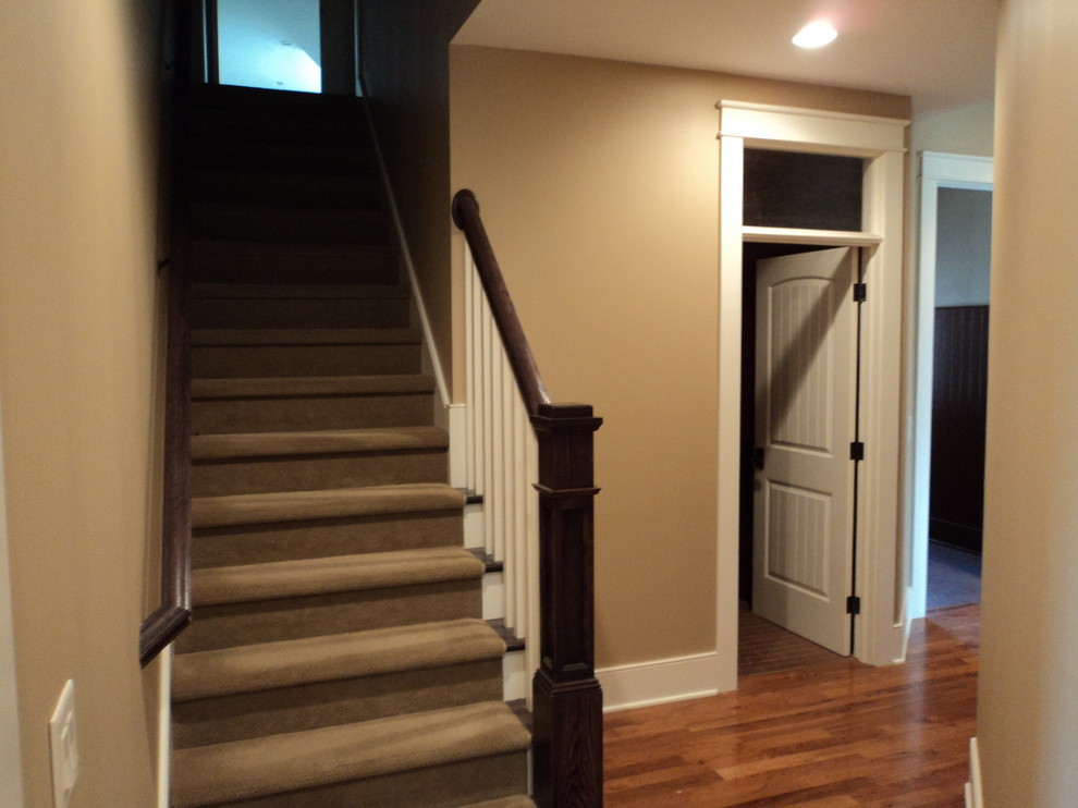На фото: прямая лестница среднего размера в классическом стиле с ступенями с ковровым покрытием с