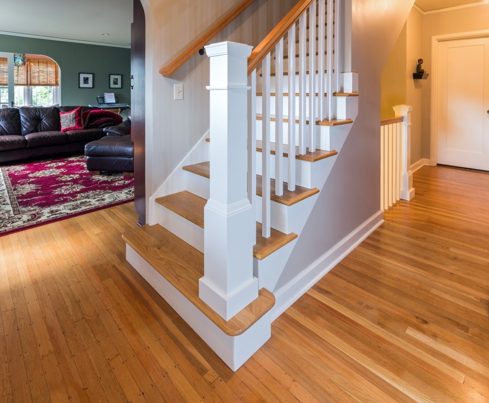 Diseño de escalera recta clásica de tamaño medio con escalones de madera, contrahuellas de madera pintada y barandilla de madera