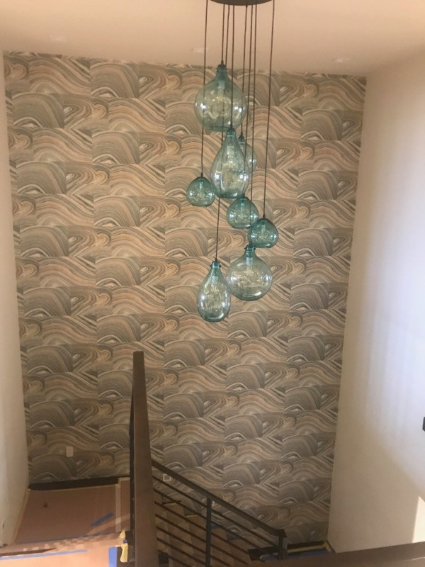 This is an example of a vintage staircase in Orange County with wallpapered walls.