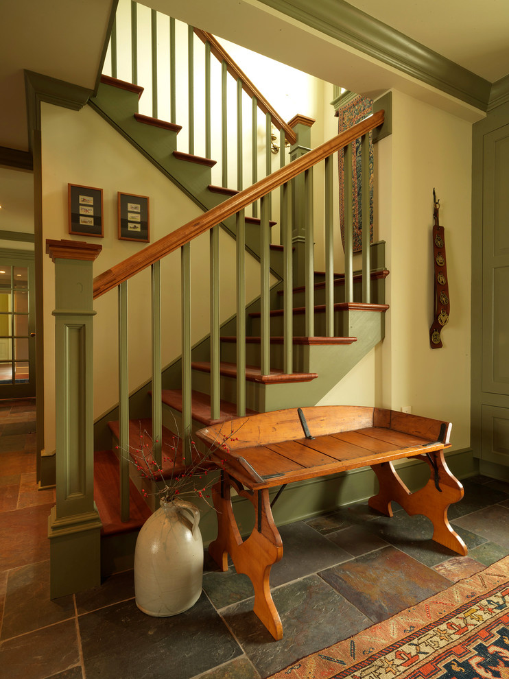 Aménagement d'un grand escalier peint classique en U avec des marches en bois et un garde-corps en bois.