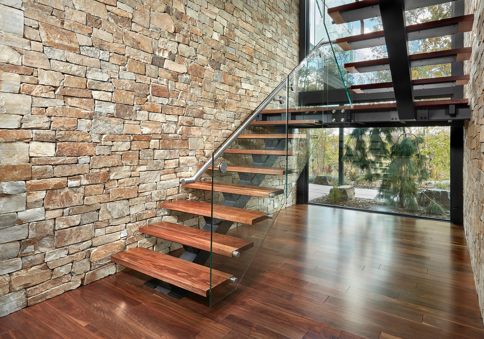 Inspiration pour un grand escalier sans contremarche design en U avec des marches en bois et un garde-corps en verre.