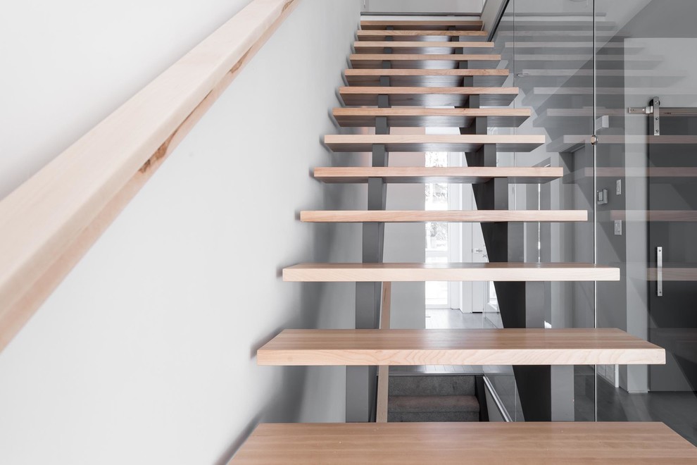 Medium sized modern wood straight wood railing staircase in Edmonton with open risers.