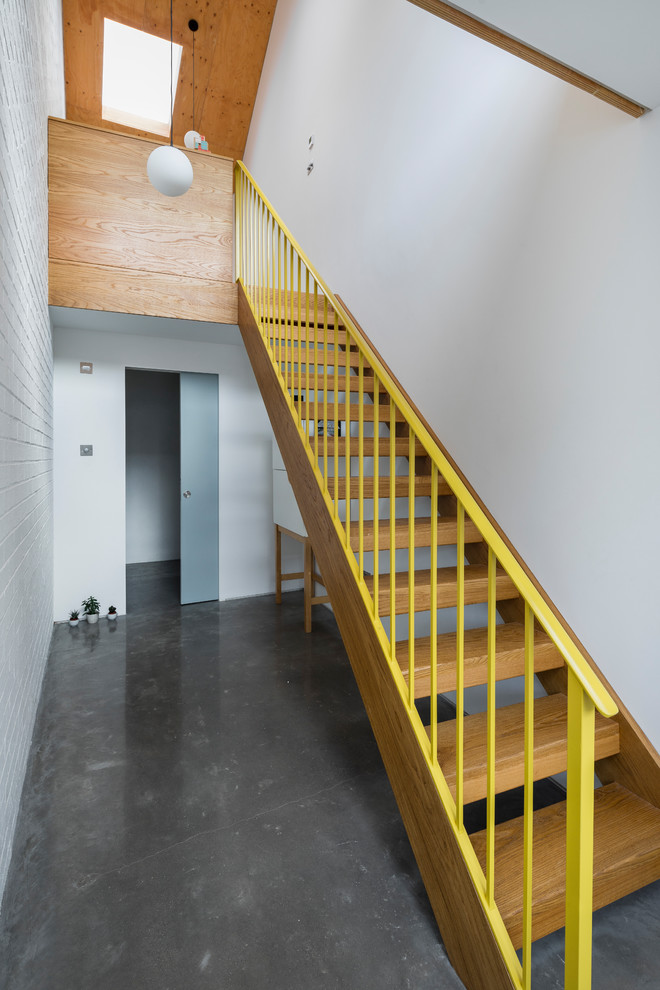 Design ideas for a contemporary wood straight metal railing staircase in London with open risers.