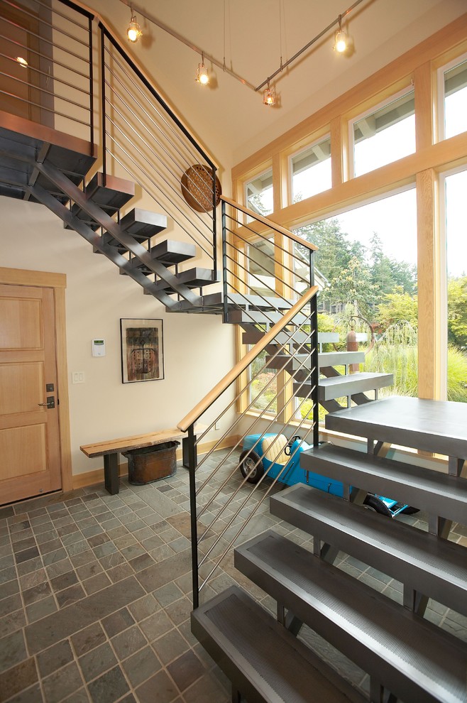 На фото: лестница в современном стиле с бетонными ступенями и кладовкой или шкафом под ней без подступенок с
