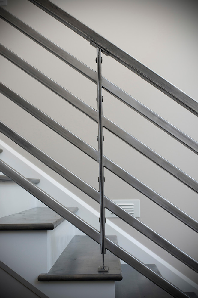 Imagen de escalera recta actual de tamaño medio con escalones de madera, contrahuellas de madera y barandilla de metal
