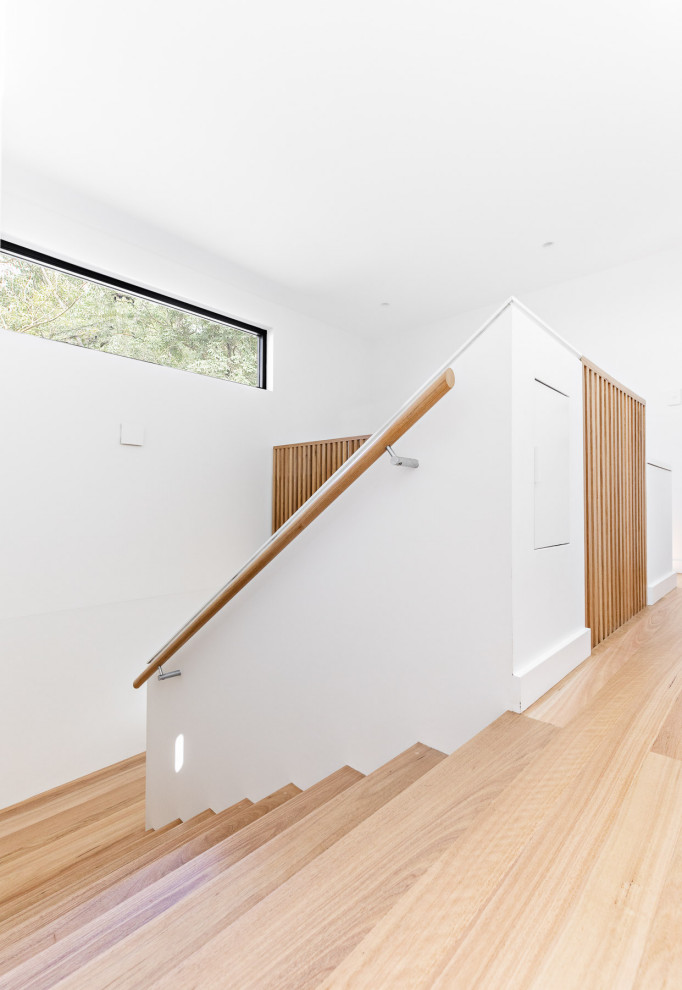 Ejemplo de escalera en U actual de tamaño medio con escalones de madera, contrahuellas de madera y barandilla de madera