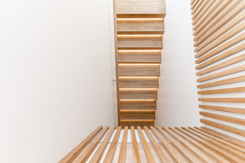 Inspiration pour un escalier design en U de taille moyenne avec des marches en bois, des contremarches en bois et un garde-corps en bois.