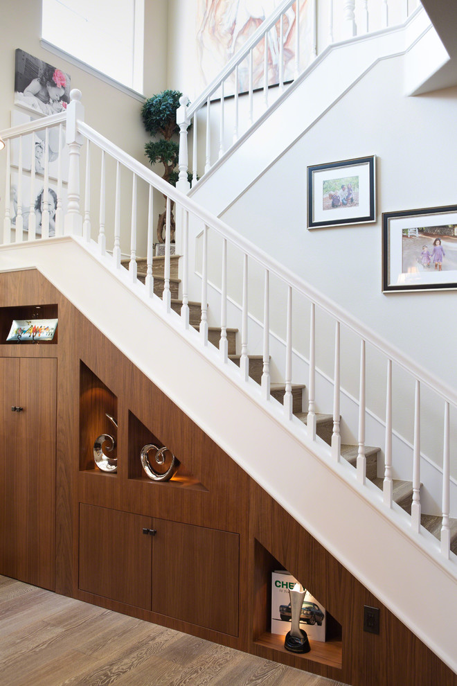 Пример оригинального дизайна: п-образная деревянная лестница в стиле неоклассика (современная классика) с деревянными ступенями и кладовкой или шкафом под ней