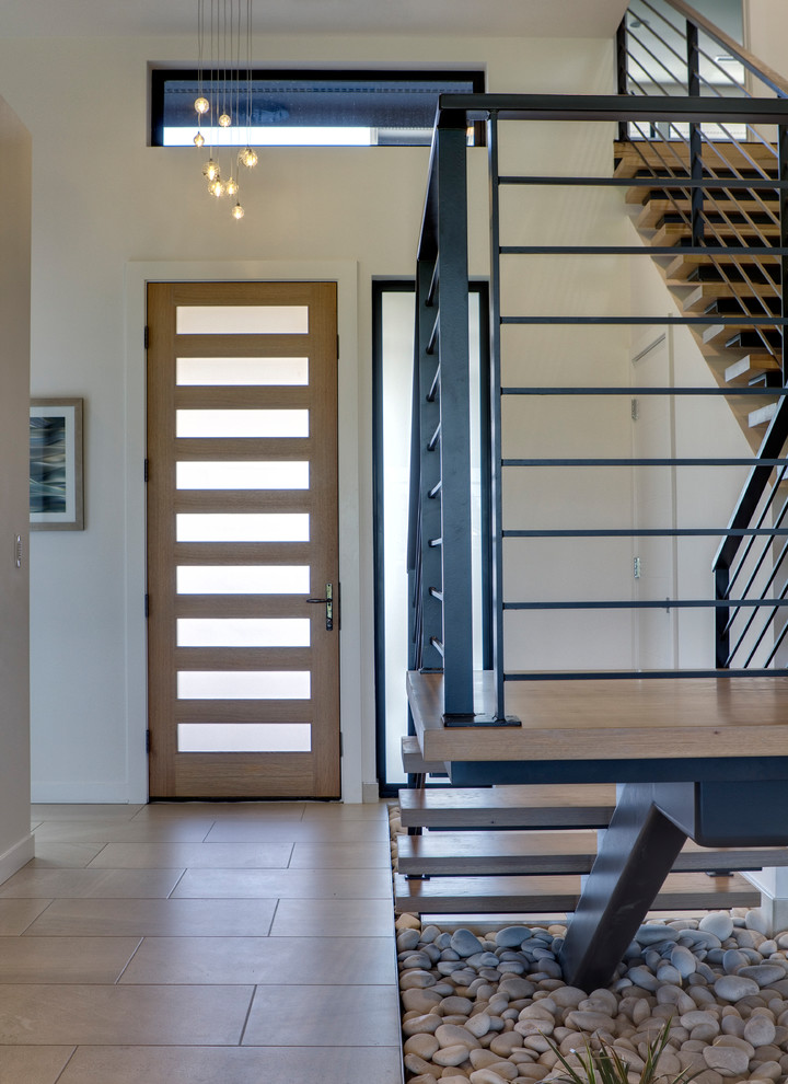 Пример оригинального дизайна: лестница на больцах, среднего размера в стиле модернизм с деревянными ступенями и металлическими перилами без подступенок
