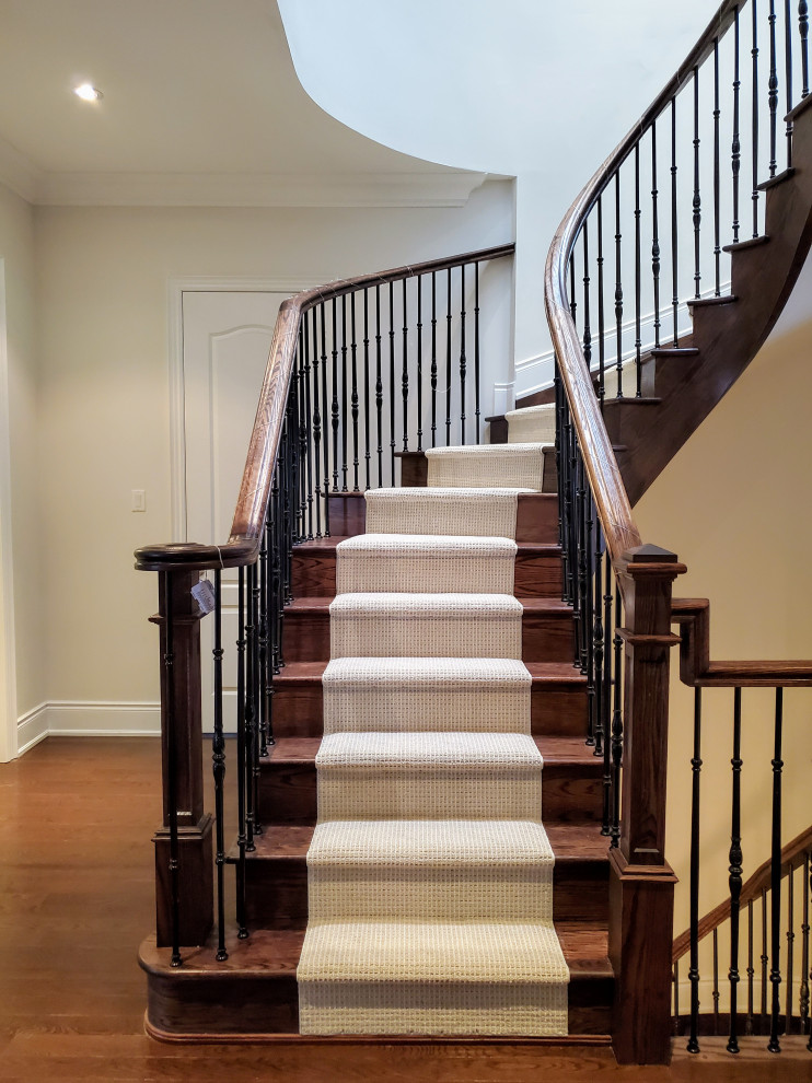 Imagen de escalera curva asiática de tamaño medio con escalones de madera, contrahuellas de madera y barandilla de varios materiales