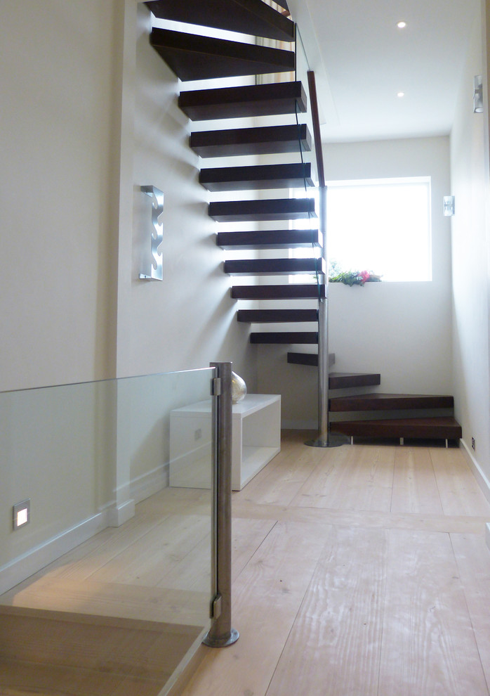 Diseño de escalera suspendida actual con escalones de madera