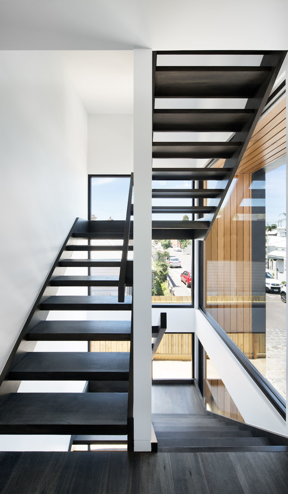Пример оригинального дизайна: лестница на больцах, среднего размера в стиле модернизм с деревянными ступенями и деревянными перилами без подступенок