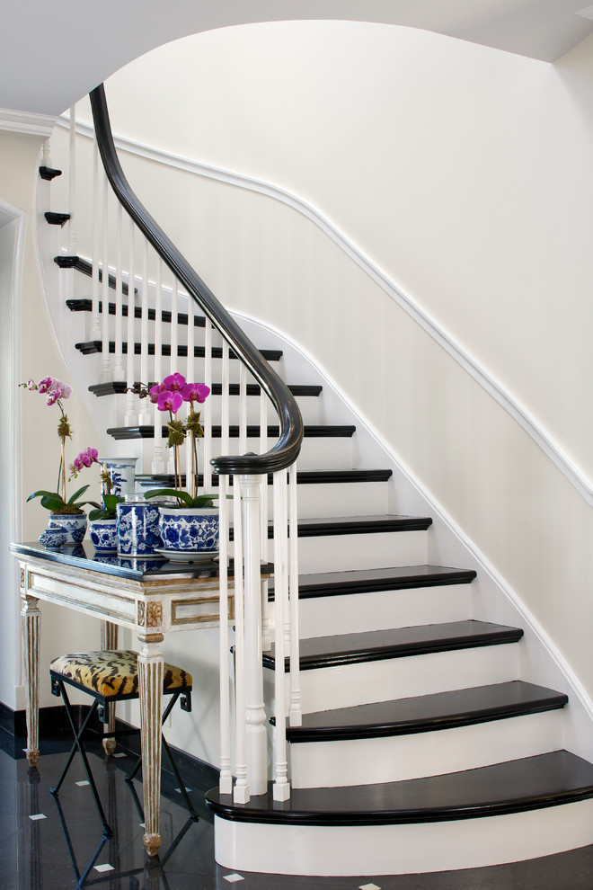Staircase - traditional curved staircase idea in Chicago with painted risers