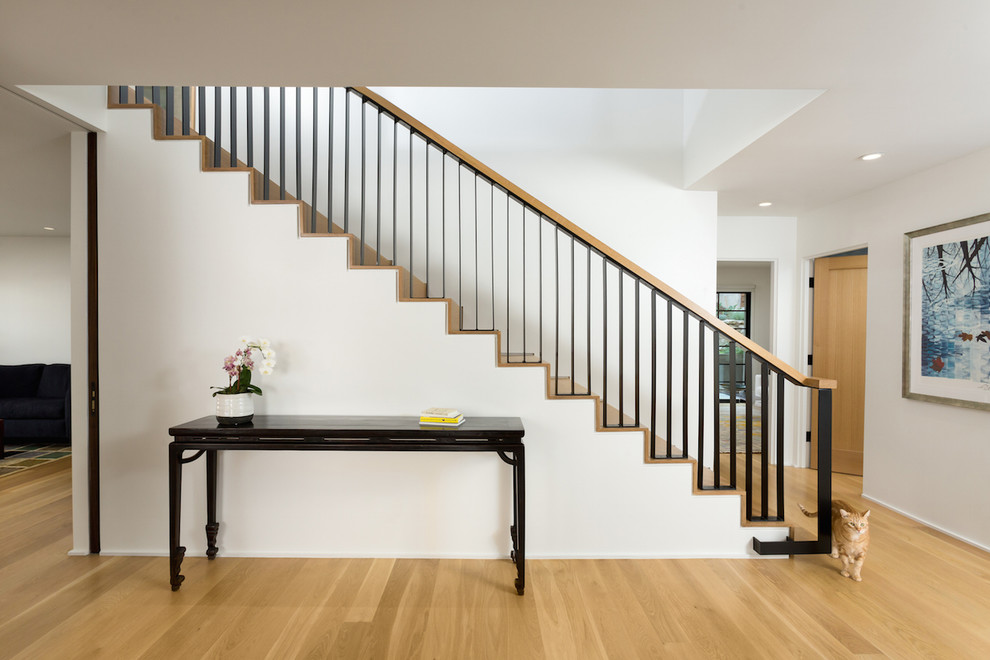 Ejemplo de escalera recta retro de tamaño medio con escalones de madera, contrahuellas de madera y barandilla de metal