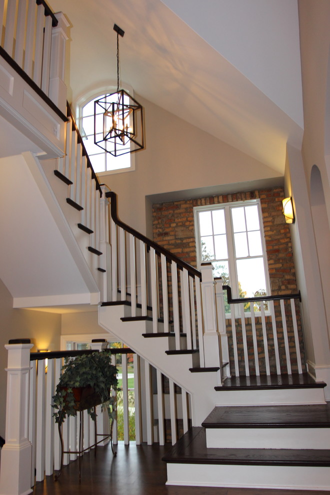 Large elegant wooden u-shaped wood railing staircase photo in Detroit with wooden risers