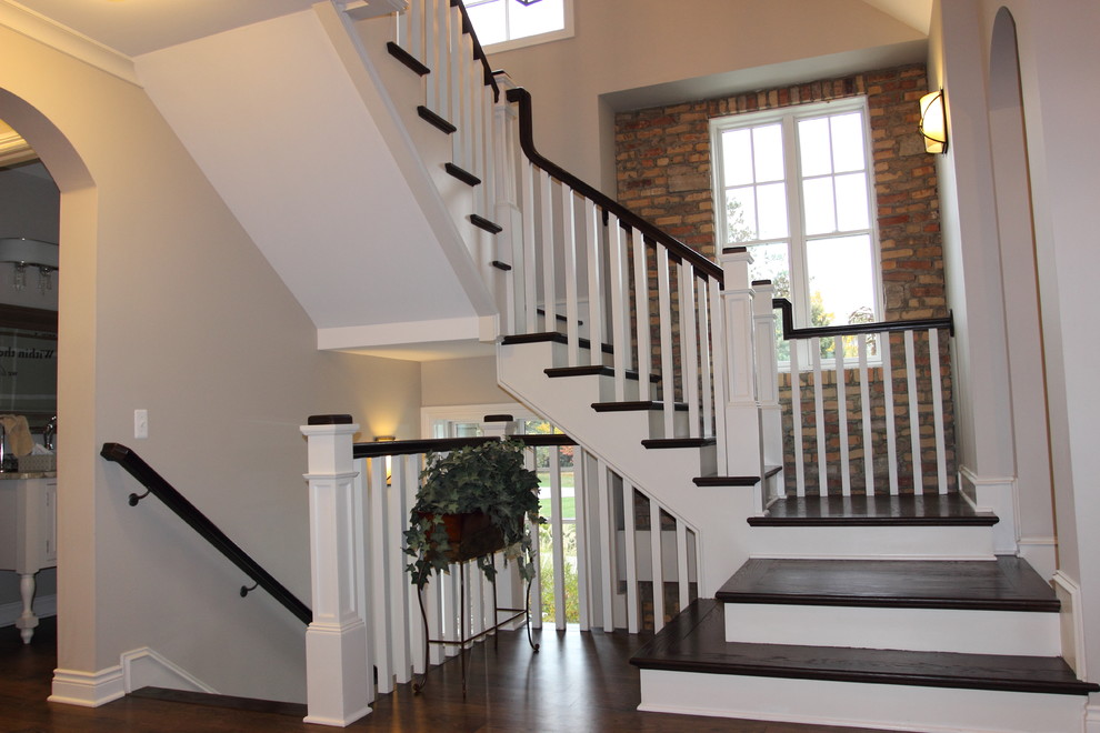 Пример оригинального дизайна: большая п-образная деревянная лестница в классическом стиле с деревянными ступенями и деревянными перилами