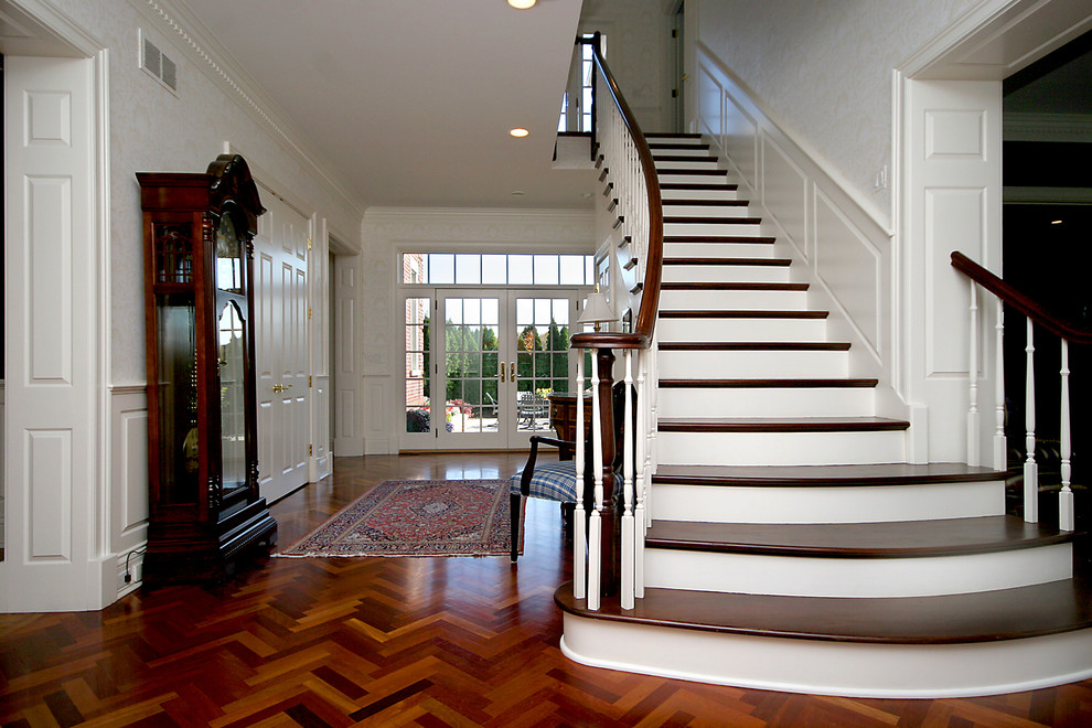 Large classic wood straight staircase in Chicago with painted wood risers.
