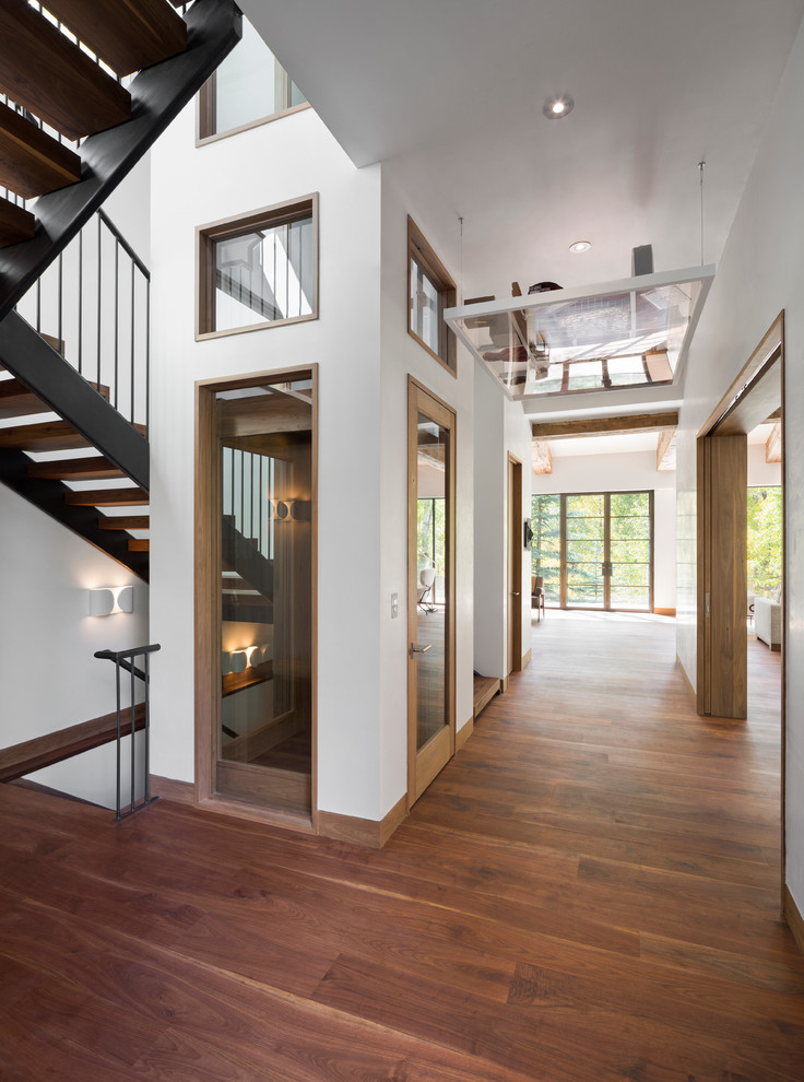 Photo of a large contemporary wood u-shaped staircase in Denver with wood risers.