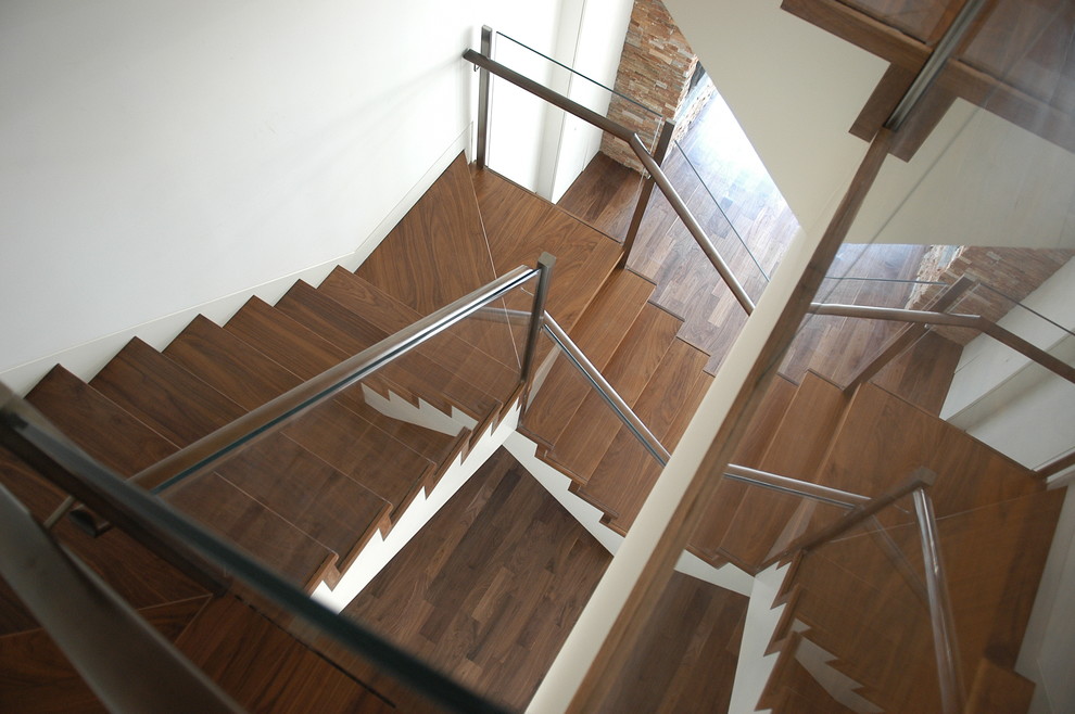 Стильный дизайн: большая деревянная лестница на больцах в стиле модернизм с деревянными ступенями - последний тренд