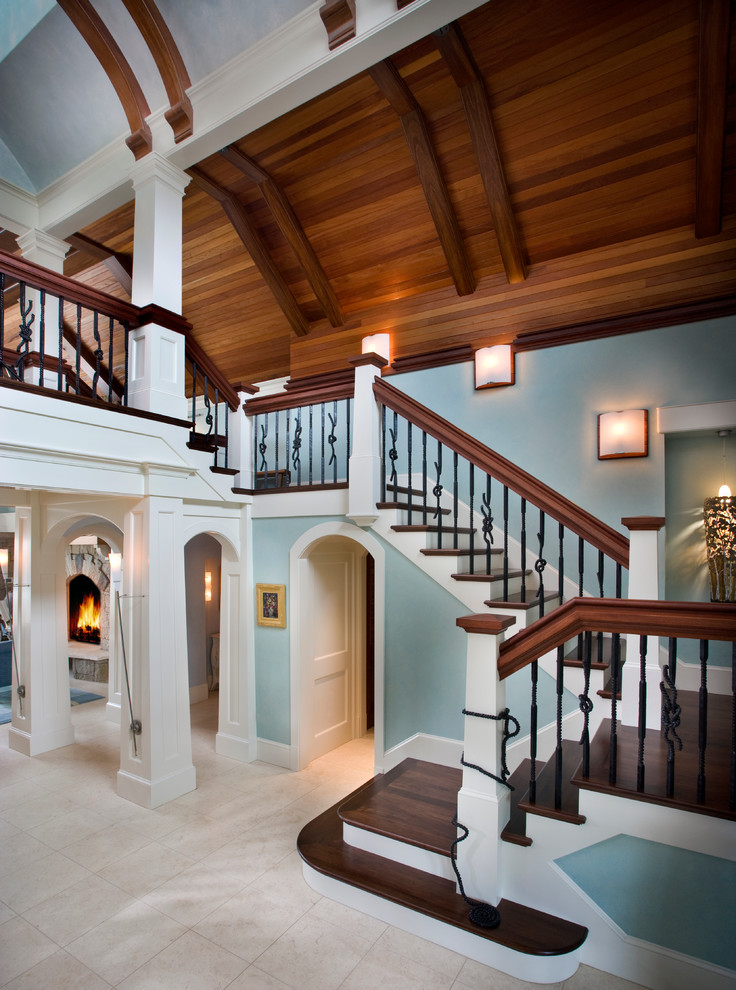 На фото: большая п-образная лестница в классическом стиле с деревянными ступенями, крашенными деревянными подступенками и перилами из смешанных материалов