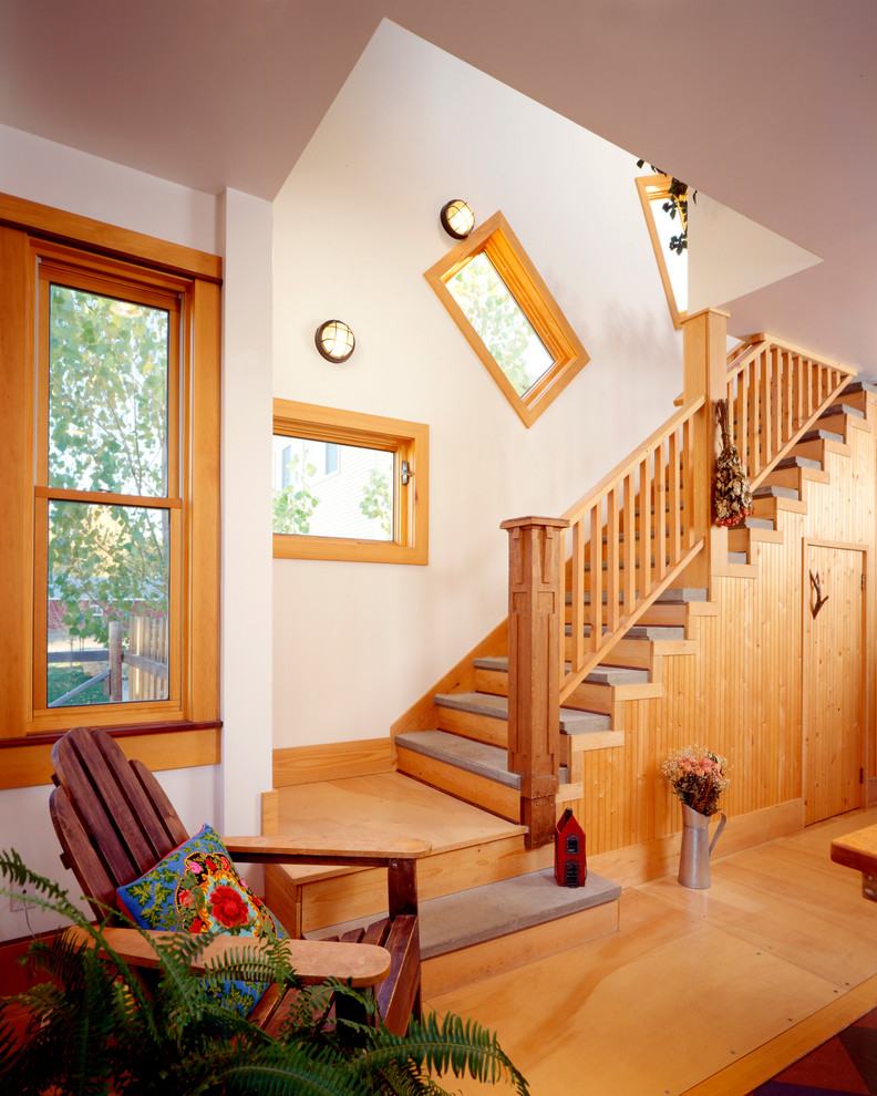 This is an example of a bohemian wood railing staircase in Denver with wood risers and under stair storage.