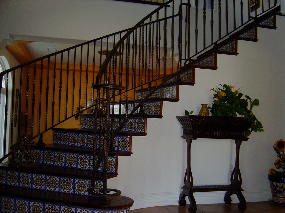 Aménagement d'un escalier courbe classique de taille moyenne avec des marches en bois et des contremarches carrelées.