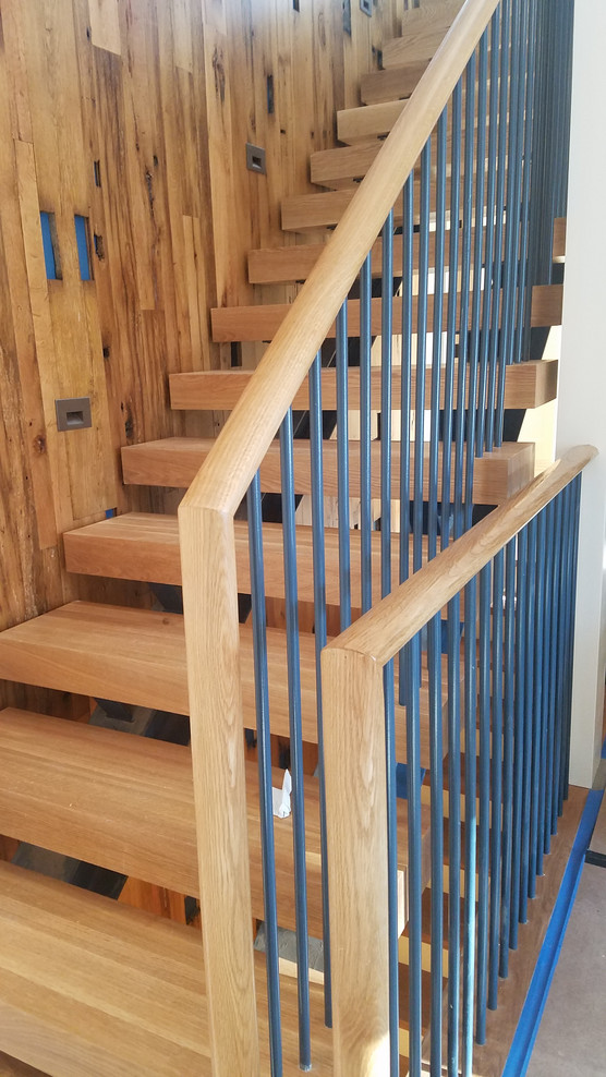 На фото: прямая деревянная лестница среднего размера в стиле модернизм с деревянными ступенями и перилами из смешанных материалов с