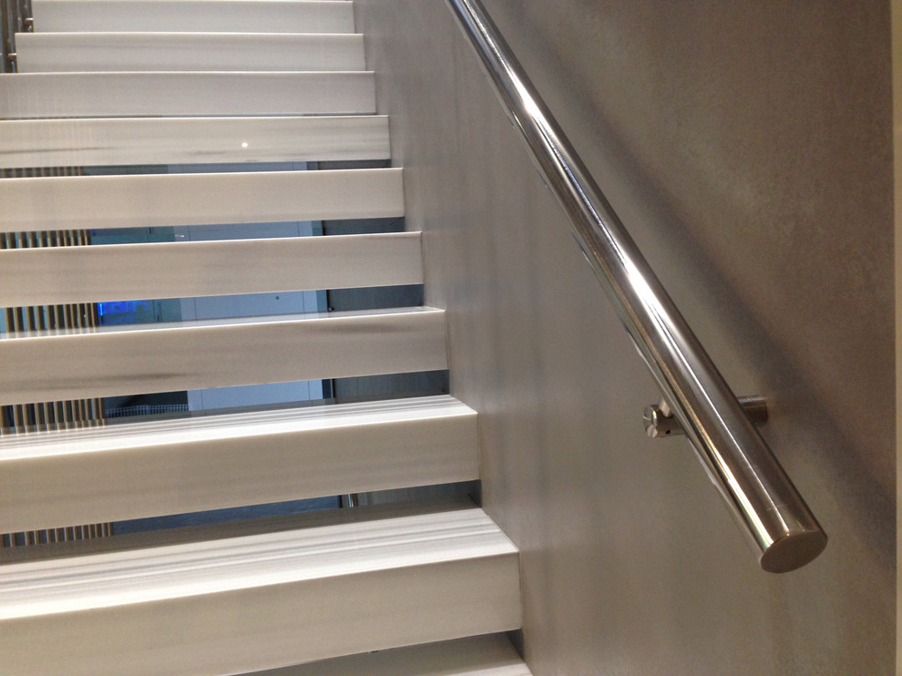 Foto de escalera suspendida actual pequeña sin contrahuella con escalones de mármol y barandilla de metal