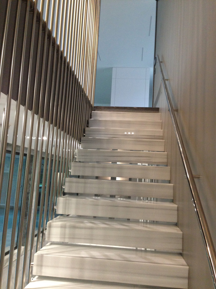 Стильный дизайн: маленькая лестница на больцах в современном стиле с мраморными ступенями и металлическими перилами без подступенок для на участке и в саду - последний тренд