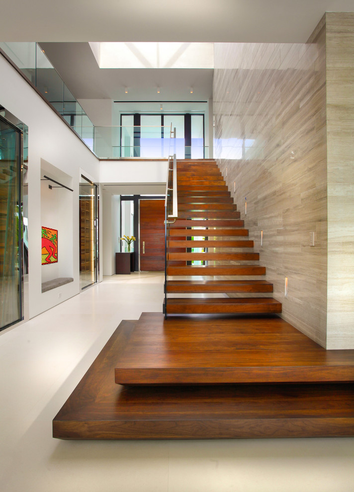 Идея дизайна: большая лестница на больцах в стиле модернизм с деревянными ступенями и стеклянными перилами без подступенок