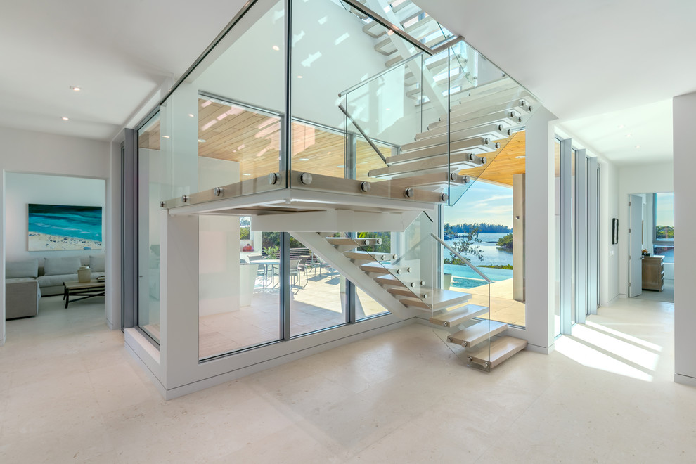 На фото: п-образная лестница в современном стиле с деревянными ступенями и стеклянными перилами без подступенок с
