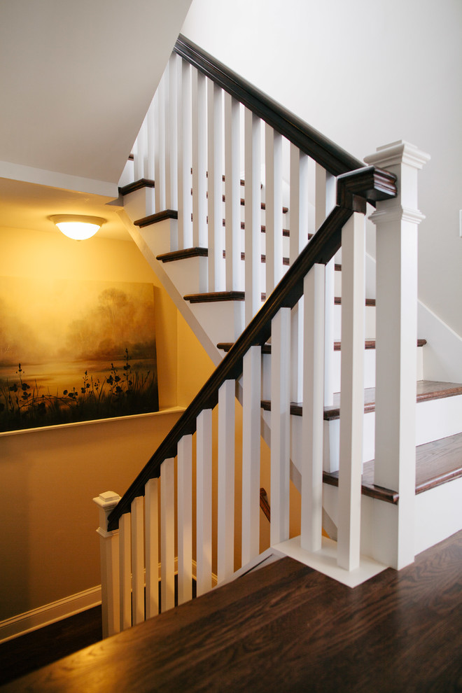 Свежая идея для дизайна: большая п-образная лестница в стиле неоклассика (современная классика) с деревянными ступенями, крашенными деревянными подступенками и деревянными перилами - отличное фото интерьера