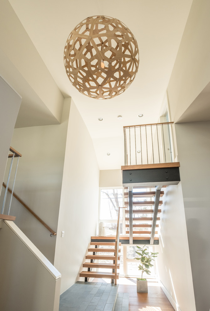 Пример оригинального дизайна: большая п-образная лестница в современном стиле с деревянными ступенями и перилами из смешанных материалов без подступенок