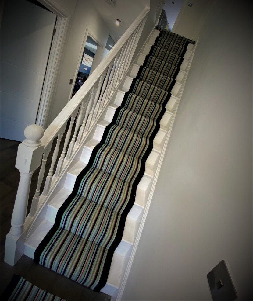 Diseño de escalera recta contemporánea grande con escalones enmoquetados, contrahuellas enmoquetadas y barandilla de madera