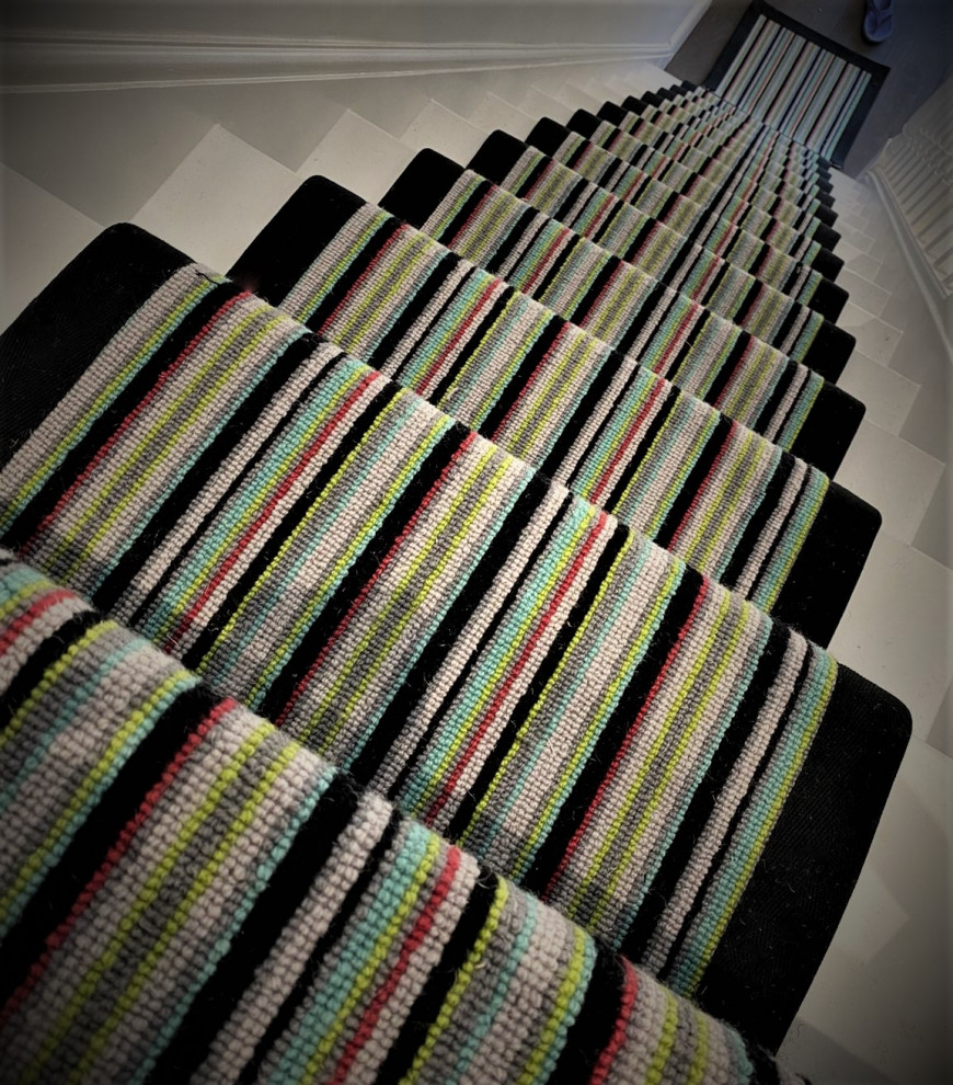 ハートフォードシャーにある広いコンテンポラリースタイルのおしゃれな直階段 (カーペット張りの蹴込み板、木材の手すり) の写真