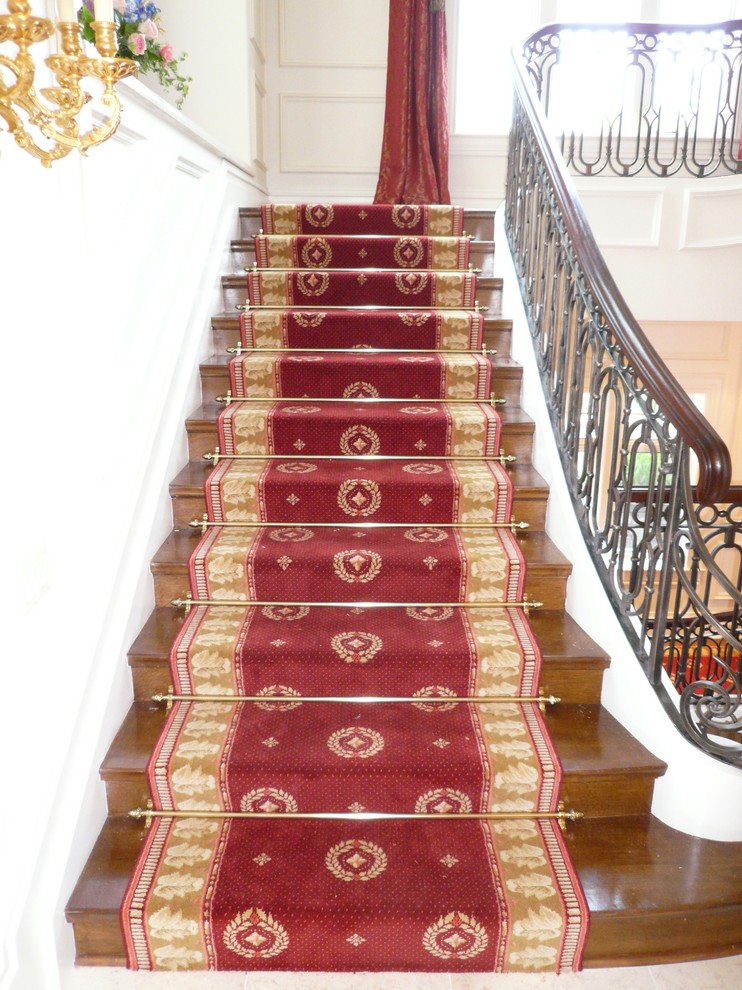 Cette image montre un très grand escalier traditionnel en U avec des marches en bois et des contremarches en bois.