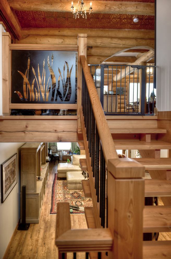 Foto de escalera en L rústica de tamaño medio sin contrahuella con escalones de madera y barandilla de metal