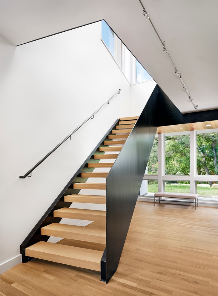 На фото: большая изогнутая лестница в стиле модернизм с деревянными ступенями без подступенок с