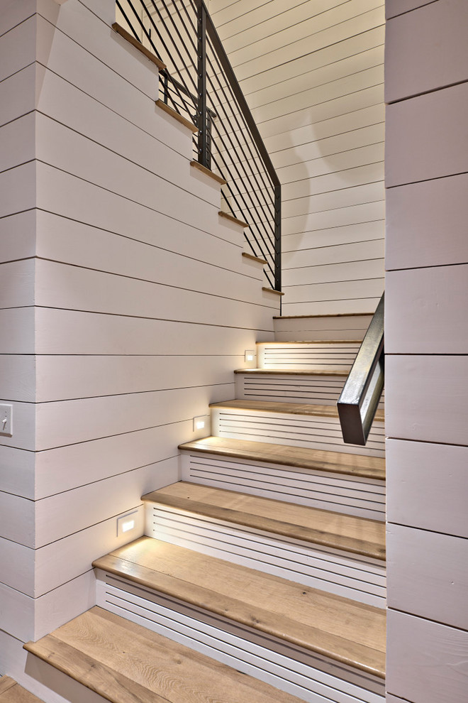 Ejemplo de escalera en U tradicional renovada grande con escalones de madera, contrahuellas de madera pintada y barandilla de metal
