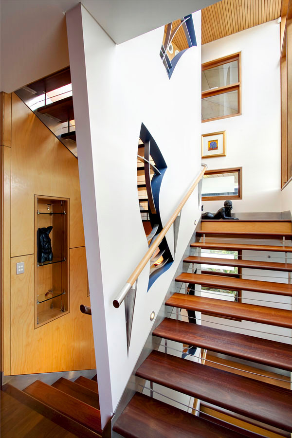 Cette image montre un très grand escalier sans contremarche traditionnel en U avec des marches en bois et un garde-corps en matériaux mixtes.