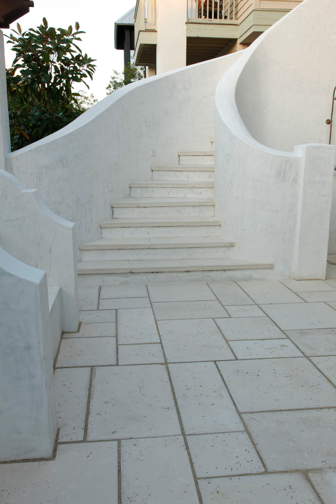 Cette image montre un escalier courbe méditerranéen en béton avec des contremarches en béton.