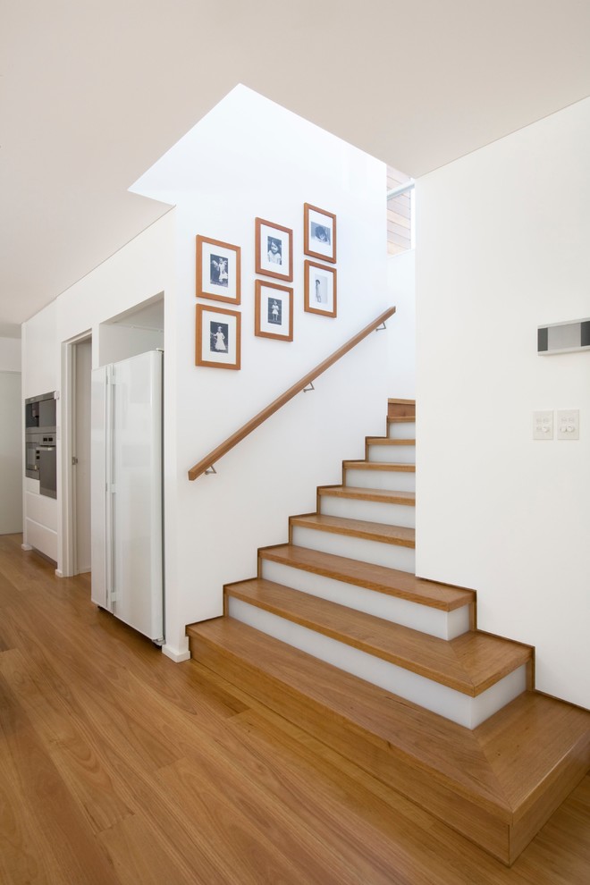 Aménagement d'un grand escalier peint classique en L avec des marches en bois.