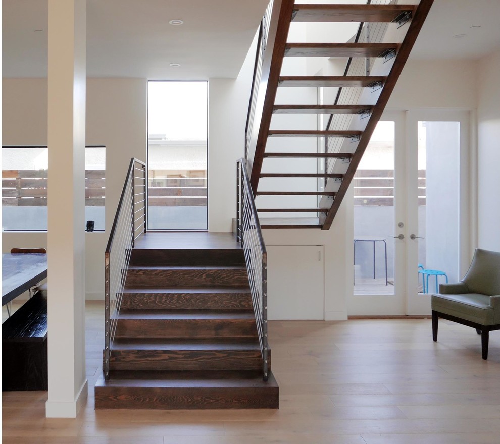 Medium sized contemporary wood u-shaped wire cable railing staircase in Los Angeles with open risers.