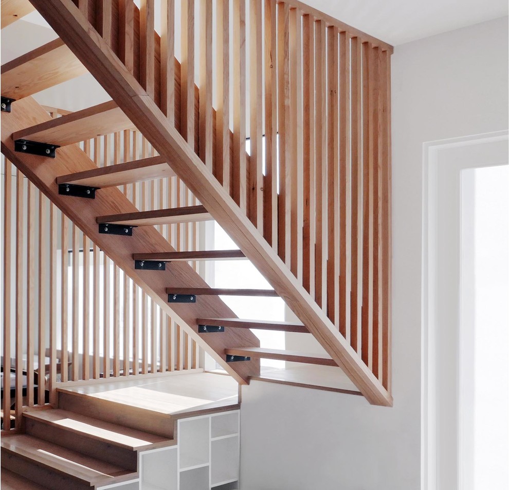Imagen de escalera en U actual de tamaño medio sin contrahuella con escalones de madera y barandilla de madera