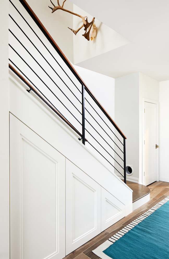 Modelo de escalera recta, moderna, pequeña, con escalones de madera, barandilla de metal y contrahuellas de madera pintada
