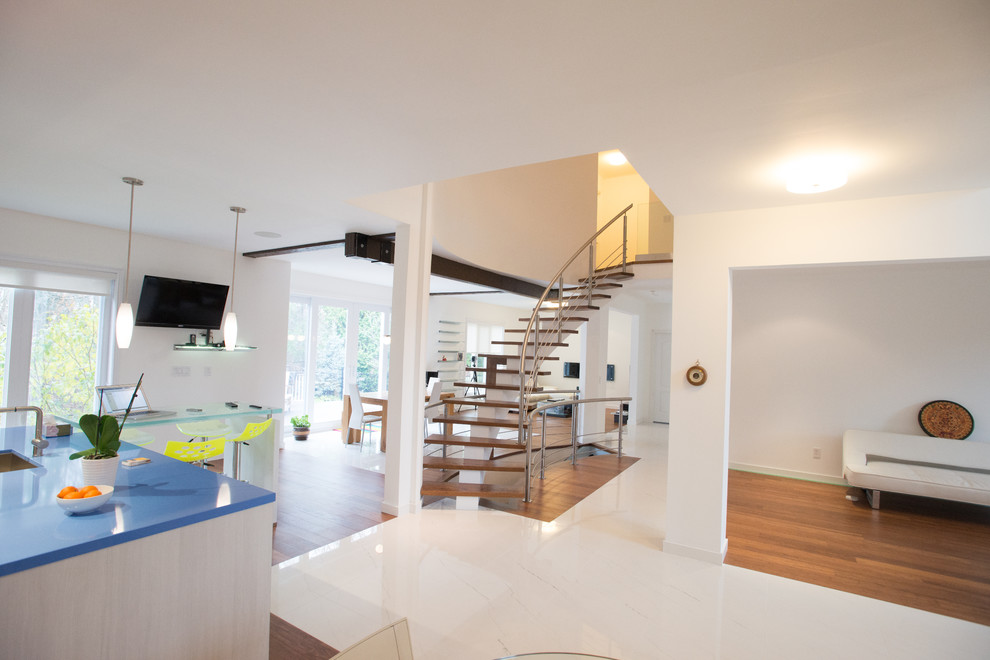 Example of a mid-sized minimalist wooden curved open staircase design in Toronto