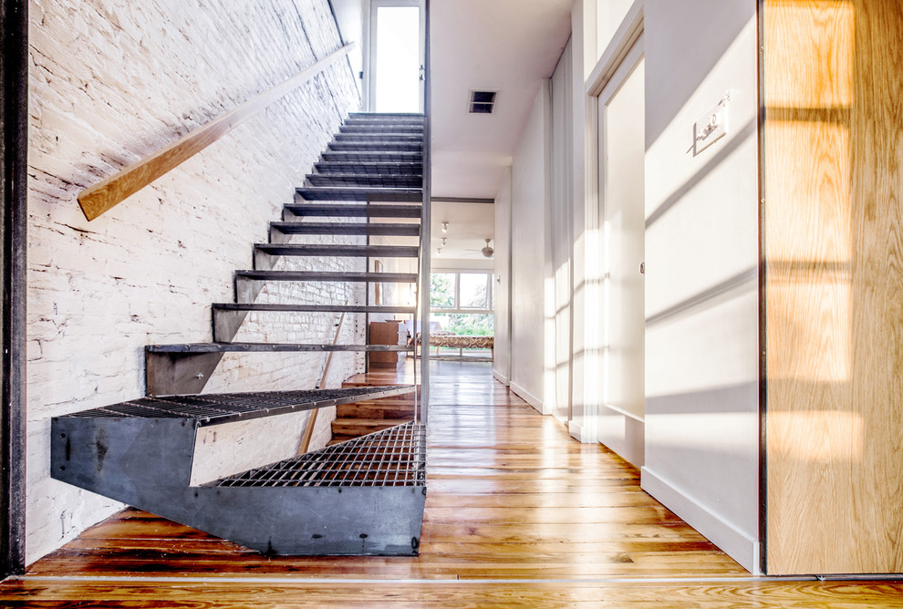 На фото: лестница на больцах, среднего размера в стиле лофт с металлическими ступенями и металлическими перилами без подступенок с