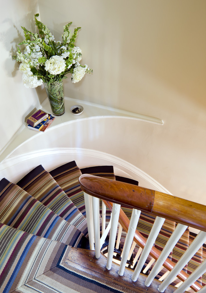 Exemple d'un escalier courbe éclectique avec des marches en moquette.